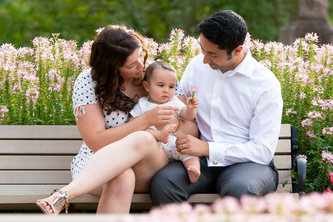 Parents et bébé sur un banc fleuri, photographe de famille Montréal